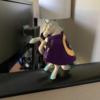 A toy unicorn wearing a cape